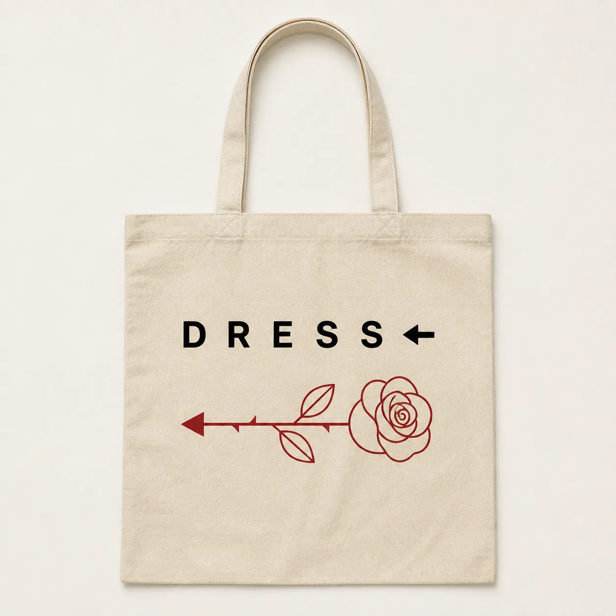 Natural canvas tote bag with DRESS wordmark, left arrow and dark red rose printed on the front