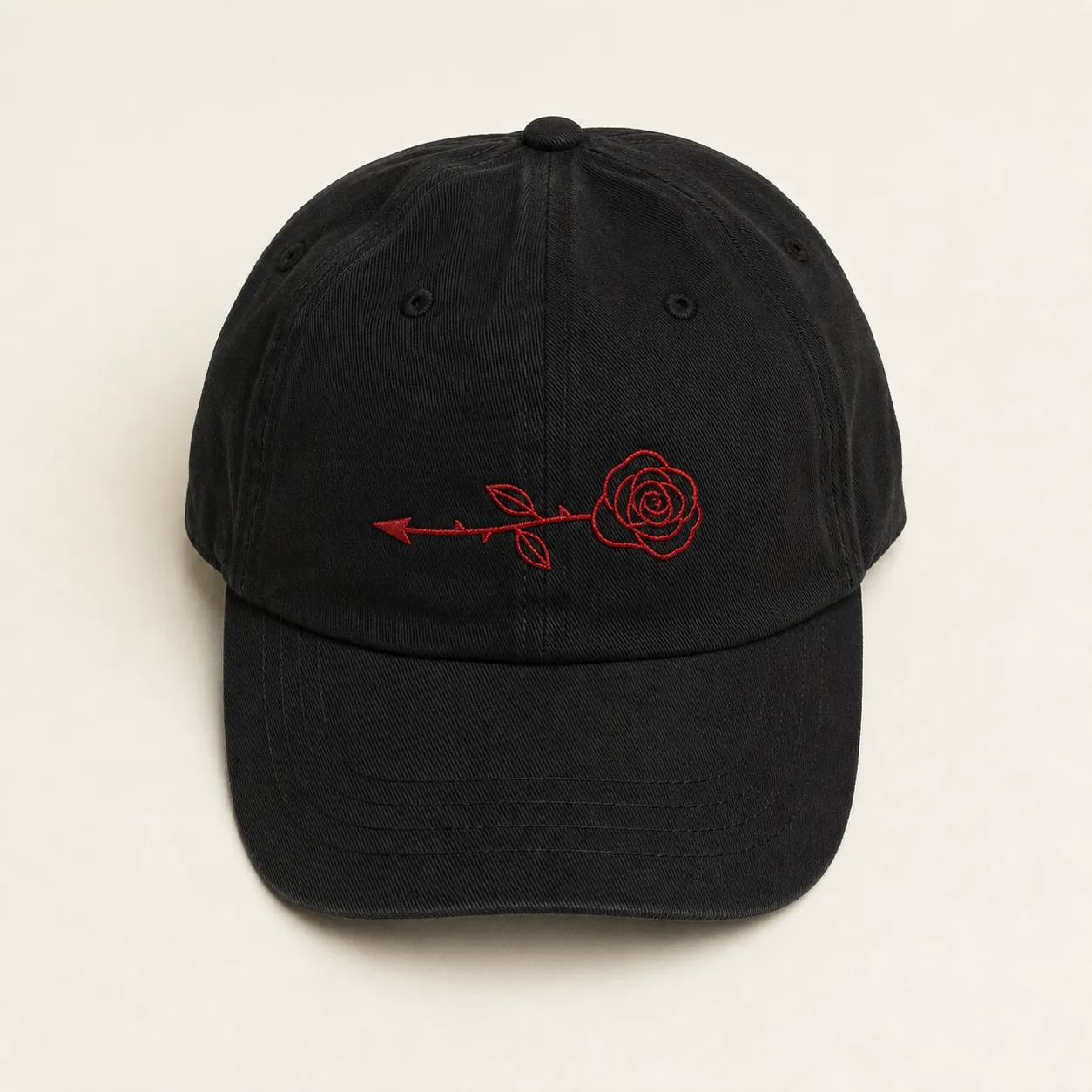 Black unstructured cotton cap with a red embroidered rose and left-pointing arrow on the front panel
